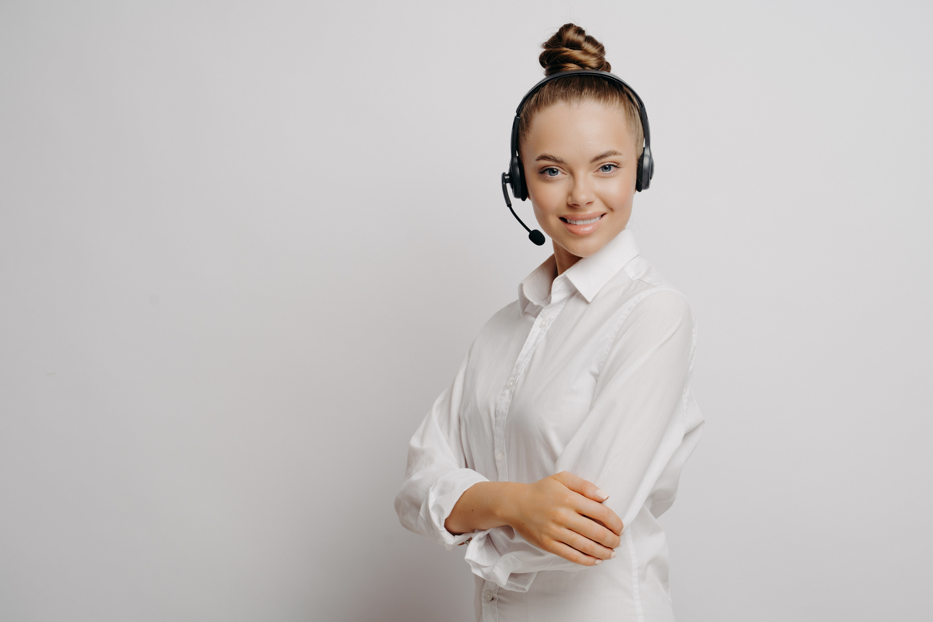 Female call center agent with black headset and crossed arms